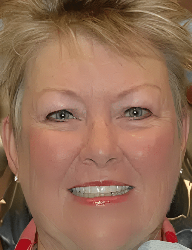 Woman smiling at camera wearing red and gold hoop earrings in professional headshot.